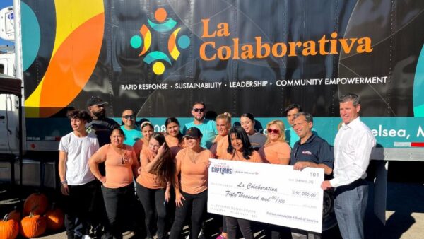 a group of people with a large check