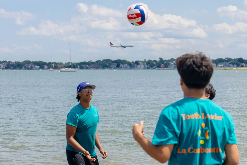 Teens playing volleyball at the beach