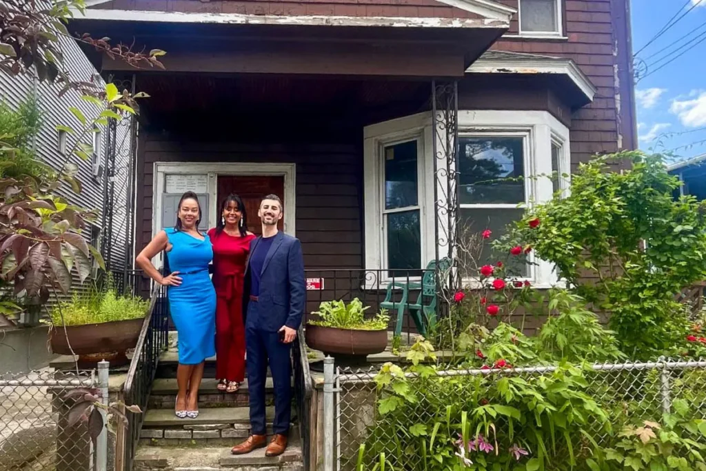La Colaborativa leadership team members standing in front of a house