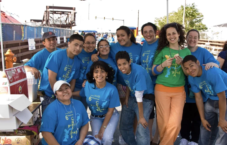 Group of people smiling wearing blue shirts