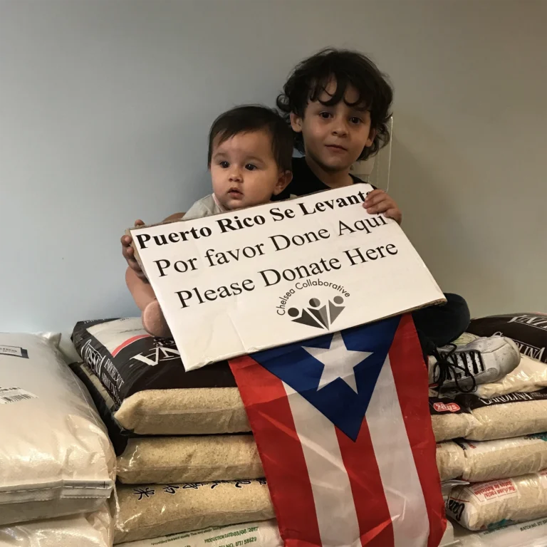 Kids sitting on rice and holding a Donate sign