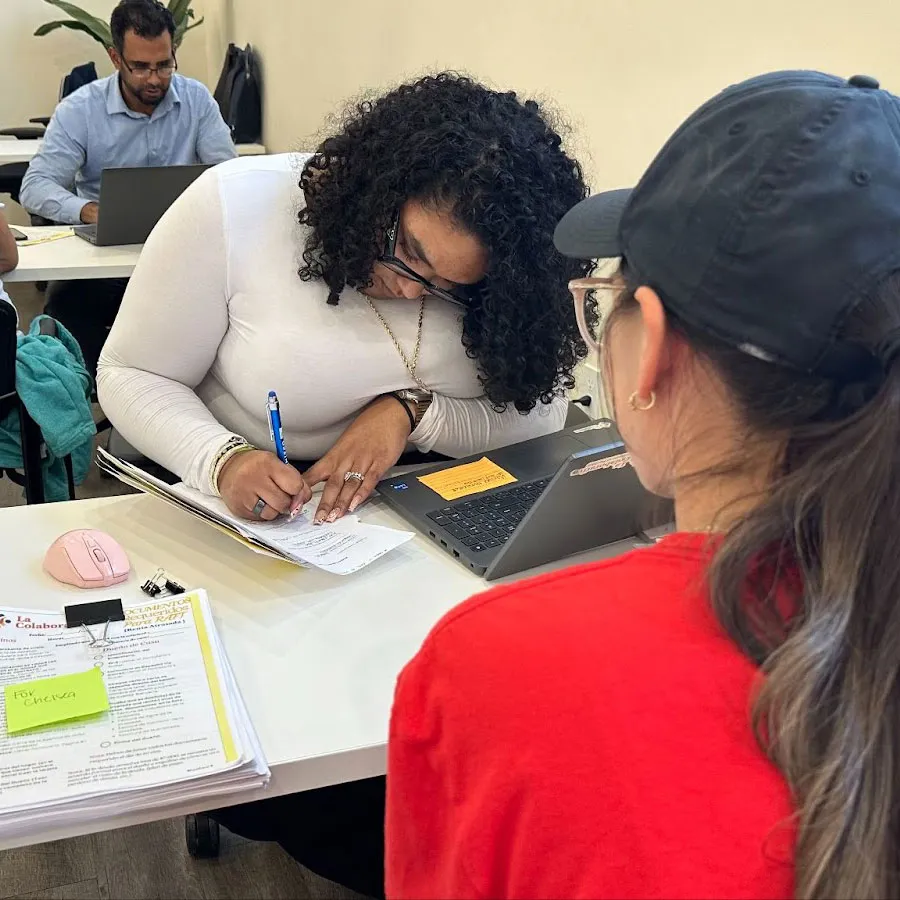 La Colaborativa helping an individual with paperwork